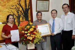 Phó Bí thư Thành ủy TPHCM Nguyễn Văn Hiếu trao Huy hiệu 70 năm tuổi Đảng cho đồng chí Đặng Văn Thân. Ảnh: HOÀNG HÙNG 