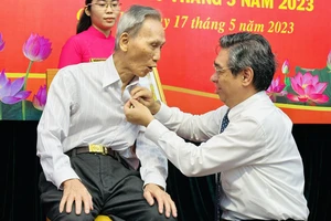 Trưởng Ban tổ chức Thành ủy TPHCM Nguyễn Phước Lộc trao Huy hiệu Đảng cho đảng viên cao tuổi Đảng. Ảnh: CHÍ THẠCH