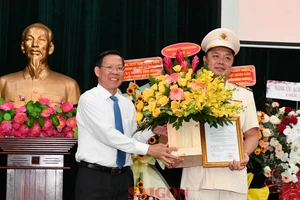 Chủ tịch UBND TPHCM Phan Văn Mãi chúc mừng tân Phó Giám đốc Công an TPHCM Nguyễn Đình Dương. Ảnh: VIỆT DŨNG 