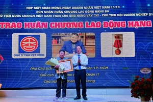 Phó Bí thư Thành ủy TPHCM Nguyễn Hồ Hải trao Huân chương lao động cho ông Hàng Vay Chi. Ảnh: CHÍ THẠCH