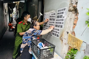 Công an cùng người dân bóc xóa quảng cáo sai quy định trên địa bàn quận Tân Bình