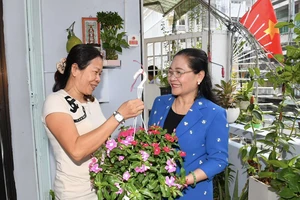Chủ tịch HĐND TPHCM Nguyễn Thị Lệ tặng hoa cho các hộ dân. Ảnh: VIỆT DŨNG