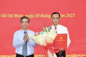 Phó Bí thư Thành ủy TPHCM Nguyễn Phước Lộc tặng hoa chúc mừng đồng chí Cao Sơn Yên. Ảnh: VIỆT DŨNG 