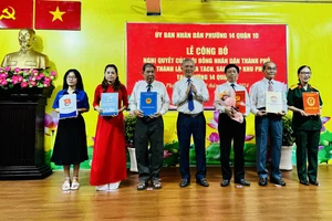 Phó Chủ tịch UBND TPHCM Ngô Minh Châu trao quyết định và tặng hoa chúc mừng đại diện các khu phố mới
