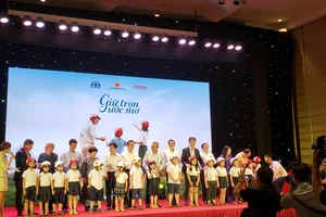 Phó Thủ tướng thường trực Chính phủ, Chủ tịch Ủy ban An toàn giao thông quốc gia Trương Hòa Bình tặng nón bảo hiểm cho học sinh lớp 1 của Hà Nội