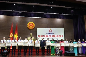 Bộ trưởng Lê Vĩnh Tân tặng bằng khen cho các tập thể, cá nhân có thành tích trong phong trào thi đua yêu nước. Ảnh: THANH TUẤN