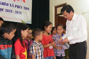 Thay mặt Báo SGGP, Phó Tổng Biên tập báo SGGP Nguyễn Ngọc Anh trao quà cho các cháu học sinh nghèo học giỏi xã Phúc Thọ