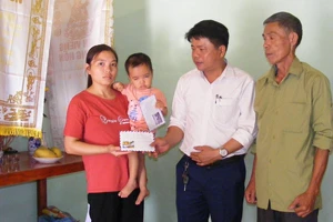 Chủ tịch UBND xã Nga Phượng Ngô Đăng Khoa trao tiền của bạn đọc Báo SGGP cho mẹ con chị Hoàng Thị Oanh