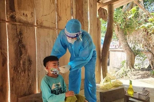 Cán bộ y tế lấy mẫu xét nghiệm cho người dân bản Chăm Puông (xã Lượng Minh, huyện Tương Dương). Ảnh: YTNA