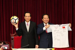 Bộ trưởng Bộ LĐ-TB&XH Đào Ngọc Dung (trái) và Bộ trưởng Bộ Thông tin và Truyền thông Trương Minh Tuấn nhận trái bóng, chiếc áo đấu của U23 Việt Nam tặng Thủ tướng Chính phủ để chuẩn bị đấu giá. Nguồn: VGP