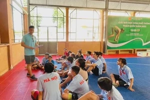 HLV Đỗ Huy Long trao đổi cùng các học viên nhí của mình tại giải bơi học sinh phổ thông toàn quốc 2022 vừa qua. Ảnh: FTSM