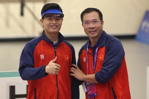 Phạm Quang Huy và HLV Hoàng Xuân Vinh sau khi giành HCV tại ASIAD 19. Ảnh: LƯỢNG LƯỢNG