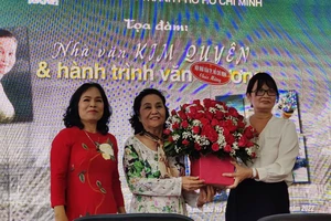 Đại diện Ban chấp hành Hội Nhà văn TPHCM, nhà văn Bích Ngân (phải) và nhà văn Trầm Hương trao tặng hoa cho nhà văn Kim Quyên như một lời chúc mừng gửi đến bà
