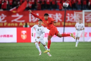 Tiền đạo nhập tịch Trung Quốc Ai Kesen tranh bóng với cầu thủ Uzbekistan