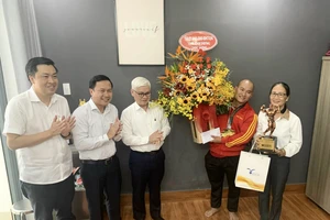 Ông Nguyễn Văn Lợi - Bí thư tỉnh ủy Bình Dương và đoàn lãnh đạo tỉnh Bình Dương tặng hoa và quà chúc mừng VĐV Hồ Huy Bình. 