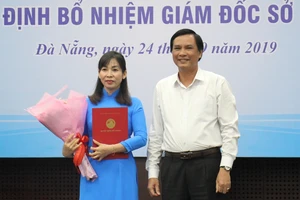 Ông Trần Văn Miên, Phó chủ tịch UBND TP Đà Nẵng trao quyết định và tặng hoa chúc mừng cho bà Trương Thị Hồng Hạnh