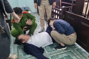 Ông Võ Văn Cường, Giám đốc Công ty TNHH MTV Land Hà Hải (áo trắng) nằm vật xuống sàn sau khi uống thuốc diệt côn trùng tự tử tại tòa