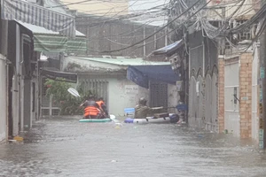 Lực lượng chức năng tiếp cận người dân khu ngập lụt bằng phao cứu sinh. Ảnh: XUÂN QUỲNH