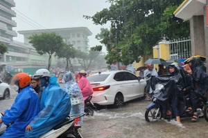 Học sinh Đà Nẵng vất vả về nhà trong thời tiết mưa lớn ngày 13-10. Ảnh: XUÂN QUỲNH