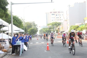 Các tình nguyện viên cổ vũ cho vận động viên tại phần thi đua xe đạp