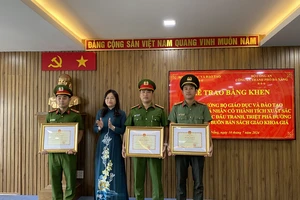 Thừa ủy quyền của Bộ trưởng Bộ GD-ĐT, bà Nguyễn Thị Hạnh trao Bằng khen cho 3 cá nhân. Ảnh: XUÂN QUỲNH
