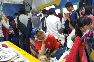 Tình nguyện viên Asiad 2018 thẫn thờ ngồi chờ đến lượt mua linh vật