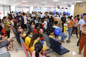 Người dân chờ đến lượt tiêm chủng cho trẻ sáng 11-7 tại Trung tâm VNVC Thanh Hóa