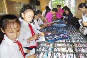 Các học sinh vùng sâu tỉnh Kiên Giang lựa kính do đoàn khám bệnh từ thiện của Hội Mắt kính TPHCM tặng