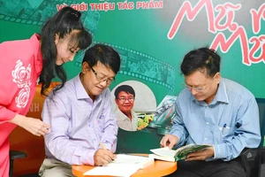 Nhà báo Huỳnh Dũng Nhân ký tặng sách cho độc giả trong buổi ra mắt tác phẩm "Chúng tôi - Một thời mũ rơm, mũ cối"