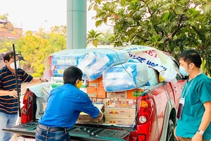 Thành viên Câu lạc bộ Xe bán tải Đà Nẵng đưa hàng hóa, nhu yếu phẩm, đồ bảo hộ chống dịch đến các khu cách ly. Ảnh: NGUYỄN CƯỜNG
