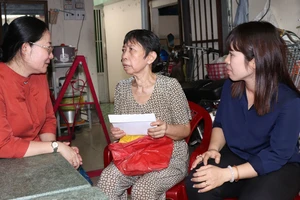 Đảng viên trên địa bàn quận 8 thăm hỏi và trao hỗ trợ cho bà Cổ Thị Thâm (giữa) thời điểm tháng 6-2020. Ảnh: THÁI PHƯƠNG