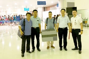 GS Phạm Như Hiệp (bìa trái) vận chuyển trái tim người hiến tặng bằng đường hàng không từ Hà Nội về Huế để ghép cho bệnh nhân Phạm Văn Cơ