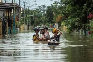 Người dân Indonesia sơ tán khỏi khu vực ngập lụt ở Gresik, Đông Java ngày 15-12-2020. Ảnh: AFP/TTXVN
