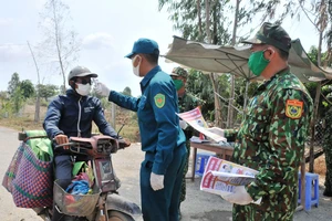 Lực lượng Bộ đội Biên phòng và dân quân tỉnh Đồng Tháp kiểm tra, đo thân nhiệt người dân ở khu vực biên giới