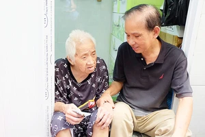 Ông Trần Văn Thanh thăm hỏi bà Trần Thị Bạch Yến, người mới được ông giúp sửa chữa nhà