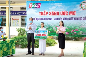 Ông Lưu Hoàng Tân - Chủ tịch, Giám đốc Công ty TNHH MTV XSKT Đồng Tháo trao học bổng cho em Đỗ Thị Kim Ngân