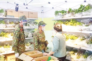 Bộ đội và dân quân đi chợ giúp dân ở phường Cô Giang, quận 1. Ảnh: LẠC PHONG