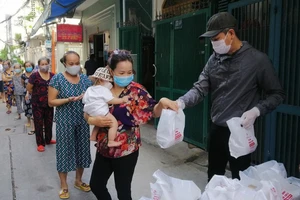 Anh Huỳnh Duy Quang Tố, Tổ phó Tổ dân phố 27, khu phố 3, phường 11 (quận Phú Nhuận, TPHCM) phát lương thực thiết yếu cho người dân có hoàn cảnh khó khăn trong tổ