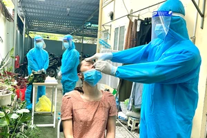 Lực lượng y tế lưu động phường 25, quận Bình Thạnh đến tận nơi điều trị cho người mắc Covid-19 tại phường. Ảnh: HOÀNG HÙNG