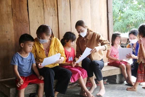 Giáo viên Trường Tiểu học Mạc Thị Bưởi (xã Ea Kiết, huyện Cư M’gar, tỉnh Đắk Lắk) đến từng nhà học sinh trong rừng sâu hướng dẫn, giao bài cho các em. Ảnh: ĐÔNG NGUYÊN