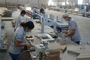 Công nhân công ty sản xuất gỗ Triệu Phú Lộc (Bình Dương) tất bật với các đơn hàng xuất khẩu