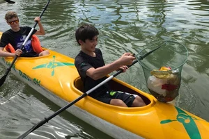 Hai du khách người nước ngoài thích thú với trải nghiệm chèo Kayak vớt rác trên sông Hoài. Ảnh: MINH HUY