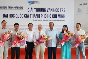 Nguyên Ủy viên Bộ Chính trị, nguyên Phó Thủ tướng Thường trực Trương Hoà Bình tặng hoa cho Ban giám khảo giải thưởng Văn học trẻ. Ảnh: NLDO
