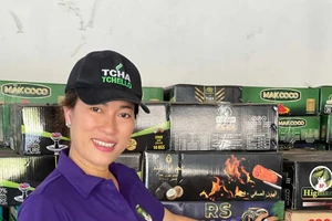 Chị Nguyễn Thị Cẩm Hằng bên sản phẩm than xuất khẩu của công ty