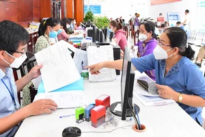 Cán bộ UBND huyện Bình Chánh, TPHCM giải quyết hồ sơ hành chính cho người dân. Ảnh: VIỆT DŨNG