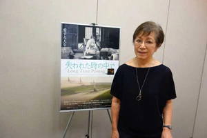 Đạo diễn Masako Sakata bên cạnh poster phim Long Time Passing