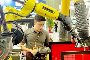 Nhân viên Công ty Makino (Khu Công nghệ cao TPHCM) điều khiển robot hàn điện, tạo chi tiết cho máy công nghiệp. Ảnh: HOÀNG HÙNG
