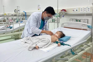 Bác sĩ đang điều trị cho bệnh nhi 9 tháng tuổi bị viêm cơ tim cấp được chuyển từ Phú Quốc (Kiên Giang) về Bệnh viện Nhi đồng 1 (TPHCM) điều trị. Ảnh: THÀNH SƠN
