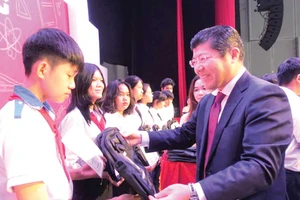 Ông Tsutomu Nara - Tổng Giám đốc công ty Ajinomoto Việt Nam trao học bổng và cặp sách cho học sinh