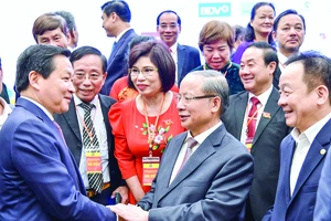 Phó Thủ tướng Lê Minh Khái (bìa trái) trao đổi với các đại biểu dự đại hội. Ảnh: VIẾT CHUNG